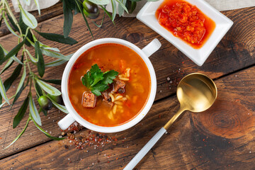 Kharcho soup with lamb meat, rice, tomatoes, carrots, peppers, walnuts and spices. Wooden background. Top view