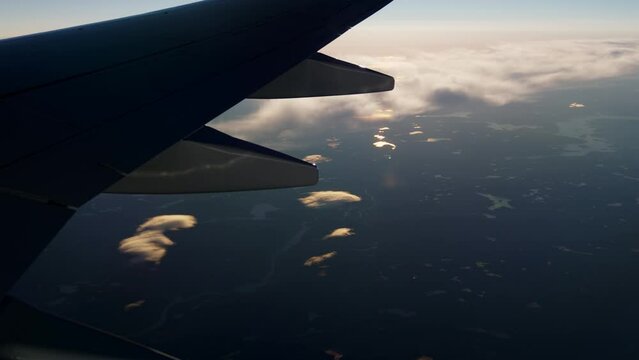 View Through Plane Window on Aircrafts Wing and Beautiful Scenery Underneath