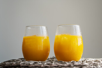 Orange juice or cocktail, cold summer lemonade on light gray background