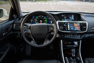Black luxury modern car interior. Steering wheel, shift lever, speedometer, display, gearbox...