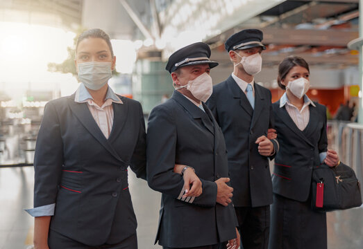 Airliner Pilot And Air Hostess Wearing Face Mask Posing In Airport Terminal