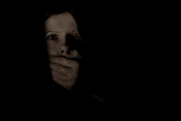 Man's hand closes the girl's mouth in the dark ,violence and fear