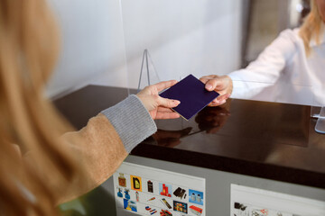 Woman handing over her passport at passport control at the airport