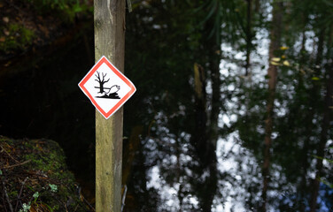 The sign of a poisoned fish on a pond. Danger of water pollution.