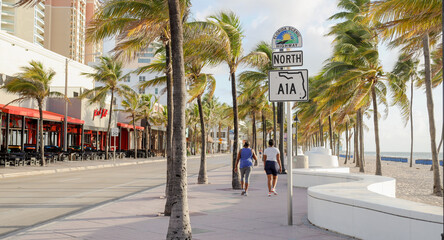 two people walking on north a1a sign in ft lauderdale beach florida  - obrazy, fototapety, plakaty