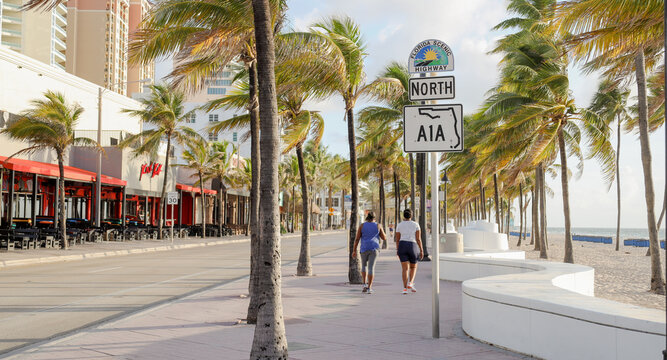 two people walking on north a1a sign in ft lauderdale beach florida 
