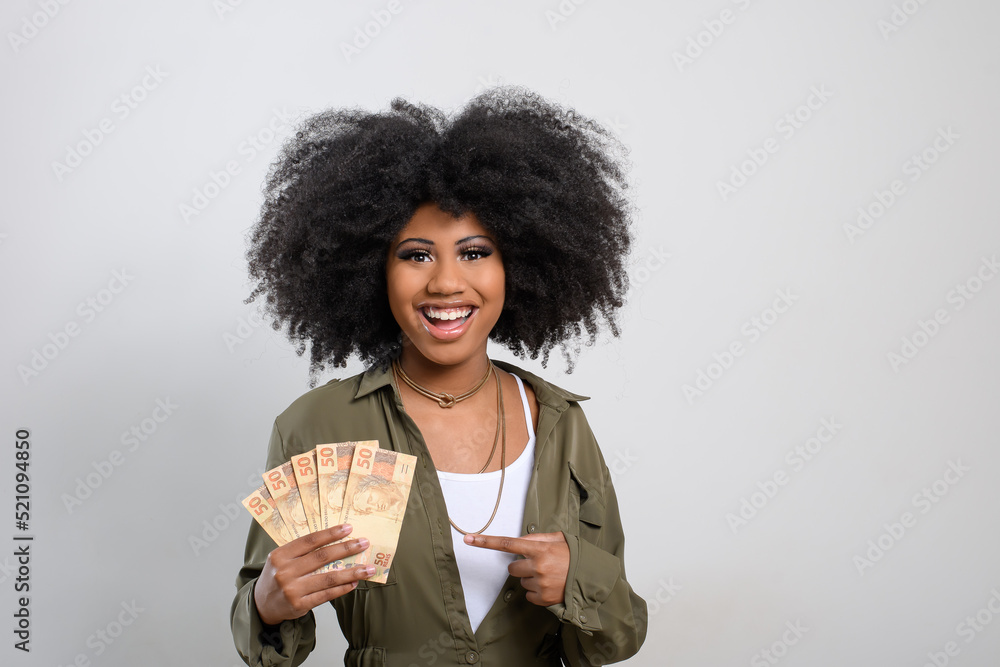 Wall mural woman holding money, brazilian money, on gray background