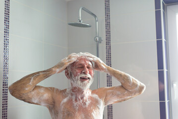 Senior man taking a shower in the bathroom in the morning - obrazy, fototapety, plakaty