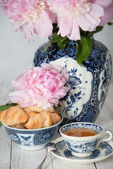 delicate spring still life with croissants and a bouquet of pink peonies 