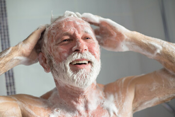 Senior man taking a shower in the bathroom in the morning