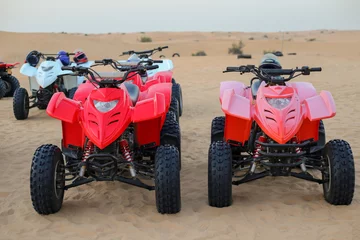 Foto op Canvas Two red ATVs stand in sand dunes. Orange desert sand landscape © Oksana