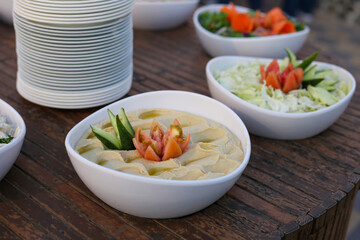 Hummus in white plate on wooden table. Arabic dish