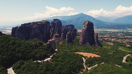 Meteora, rock formation in central Greece. Far away aerial shot of famous Greek travel destination. Sunny weather. Nature and humans. High quality photo