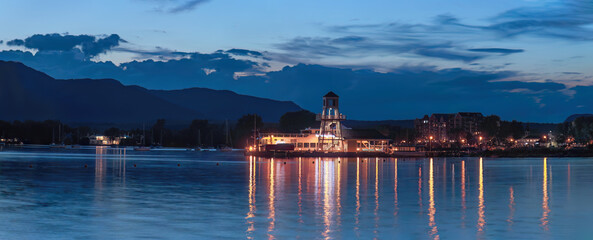 Obraz premium Magog harbor dock and lighthouse at night Memphremagog lake sunset light water and sky