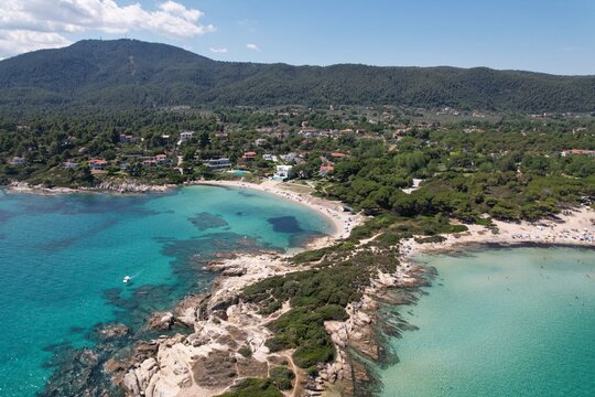 Calm Karydi beach near the village of Vourvourou in Greece. Aerial drive view of seashore and shallow see-through turquoise water. High quality photo
