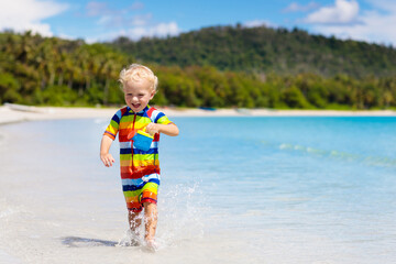 Kids play on tropical beach. Sand and water toy.