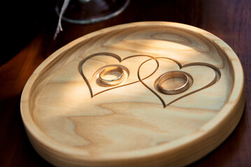 wedding rings lie on a stand with painted hearts