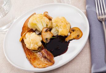 Appetizing cauliflower with bacon and mushrooms. High quality photo