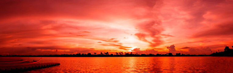 Naklejka premium Sunset in the evening with orange, yellow and pink skies. Breathtaking night view with sunset in the evening. horizon banner sky of sunset or sunlight for four seasons background