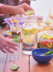 Top view of group of people having dinner together while sitting at wooden table. Food on the table. People eat fast food.