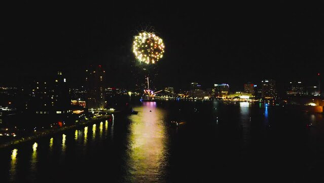 A speedy aerial flying from left to right across the night sky of Norfolk Virginia on July 4th.   The sky is lit up with a cascade of colorful fireworks to celebrate Independence Day.