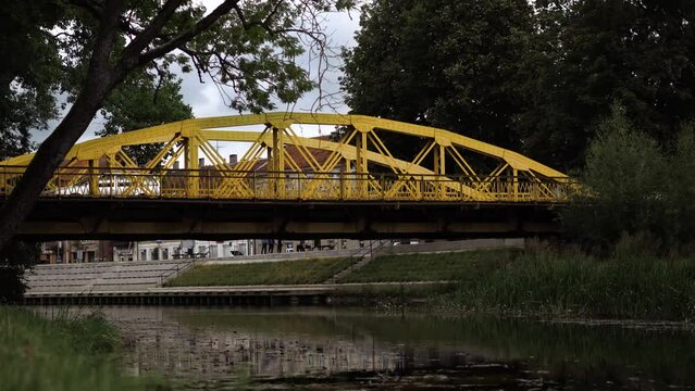 Famous Yellow Bridge in Silute, Lithuania. European one way bridge with cars passing by.