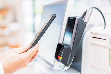 スマホ決済で支払う若い女性