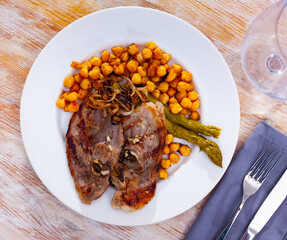 traditional spanish mutton with beans served on blue plate on wooden table