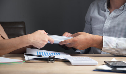 Fototapeta premium man and woman handing documents to each other