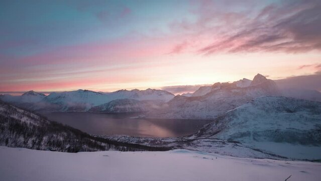 Sunrise over snowy mountain peak in blizzard on Segla mount in the morning at Senja island, Norway