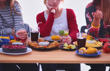 Top view of group of people having dinner together while sitting at wooden table. Food on the table. People eat fast food.