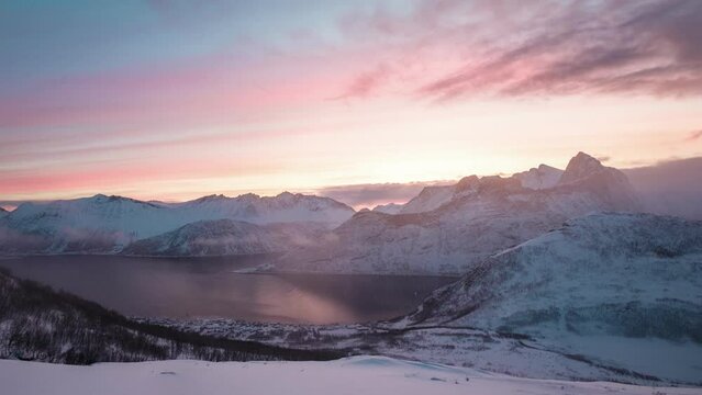 Sunrise over snowy mountain peak in blizzard on Segla mount in the morning at Senja island, Norway