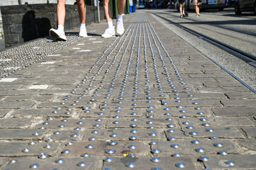 Tactile paving on sidewalk in the city. Tactile blister concrete blocks to assist pedestrians who...