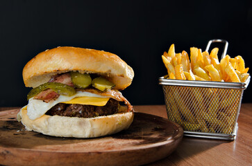 the photograph shows a delicious hamburger accompanied by french fries