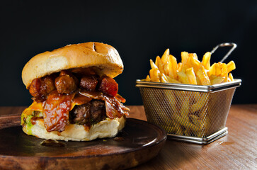 the photograph shows a delicious hamburger accompanied by french fries