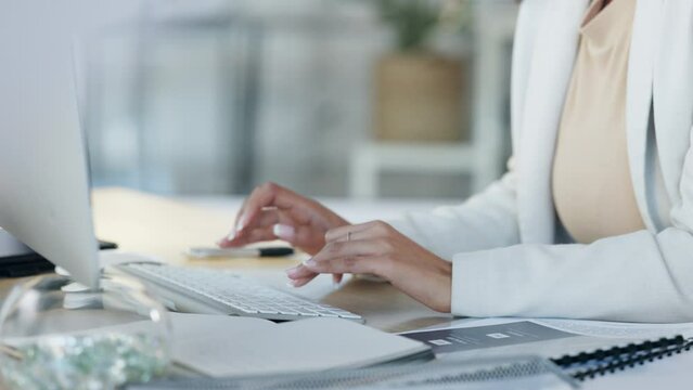 Female hands typing an email on her computer keyboard with her sitting her office desk. Close up of a professional businesswoman writing an online proposal for a corporate company she is working for