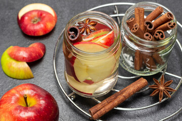 Cinnamon and apple infused water in glass jar.