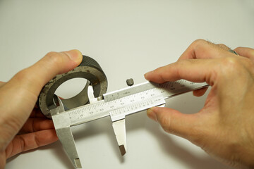 engineer's hand uses a vernier caliper that is checked with a ring gauge,calibration concept