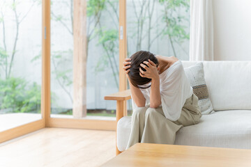 リビングで落ち込むミドル女性