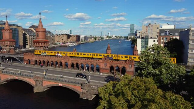 Yellow subway crosses the red brick bridge.
Amazing aerial view flight pedestal up drone footage
of Oberbaumbr&uuml;cke Berlin Friedrichshain sunny Summer day 2022. Cinematic from above by Philipp Marnitz