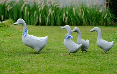 Duck family statue placed in a green park.