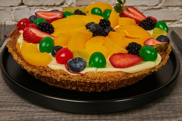 fruitcake with strawberries, blueberries, cherries and peaches close-up view