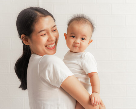 Young asian mom and sweet baby daughter, Health care family love together. Asia mother's day concept. Looking to camera.