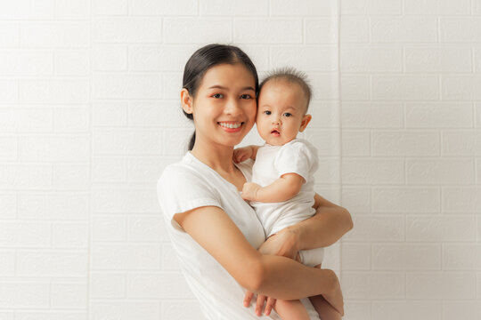 Young asian mom and sweet baby daughter, Health care family love together. Asia mother's day concept. Looking to camera.