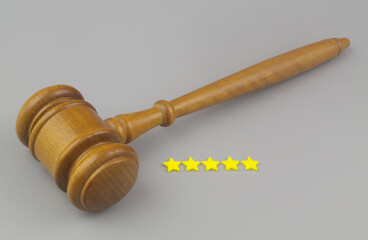 Legal service with good feedback concept. Judge gavel and 5 stars on gray background close up.t.