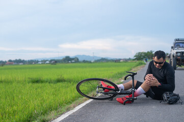Naklejka premium bike injury Male cyclist falls on a road bike while riding a bicycle. Bicycle accident, knee injury Sport outside concept.