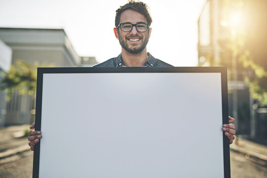 Copyspace, marketing and advertising with a young business man holding a blank sign or poster. Portrait of a creative male showing ad copy space to promote a startup, service or design company
