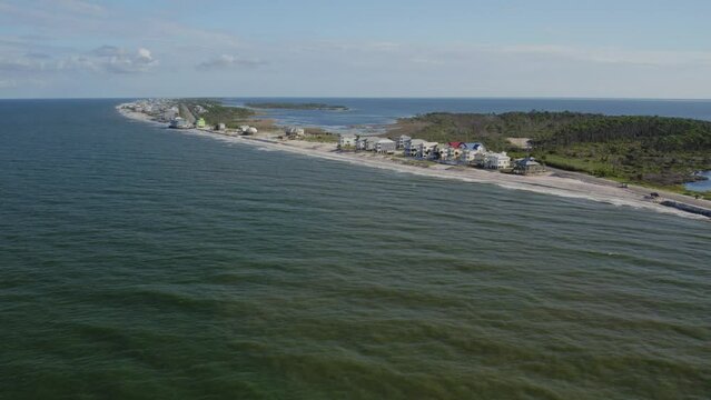 Aerial flight from the Gulf Coast towards beach front homes along a Florida peninsula