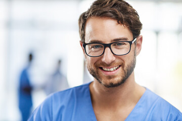 Obraz premium Portrait of a happy professional young doctor working as a surgeon in a hospital. Confident man in the medical healthcare workspace. Expert man in health smiling and ready to help or aid patients.