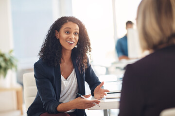 Interview with a happy, excited and confident human resources manager talking to a shortlist candidate for a job. Young business woman meeting with a colleague or coworker in her office at work - obrazy, fototapety, plakaty